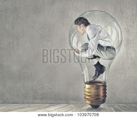 Screaming businessman trapped inside of light bulb