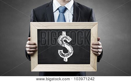 Unrecognizable businessman holding blackboard with drawn dollar concept