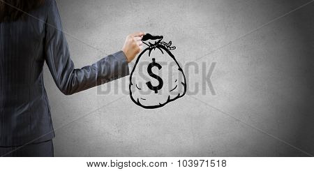 Back view of businesswoman holding drawn money bag