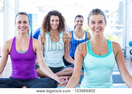 Protrait of women smiling while doing easy pose in fitness studio