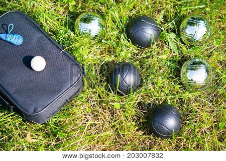 Set of bowls for playing bocce on a green lawn
