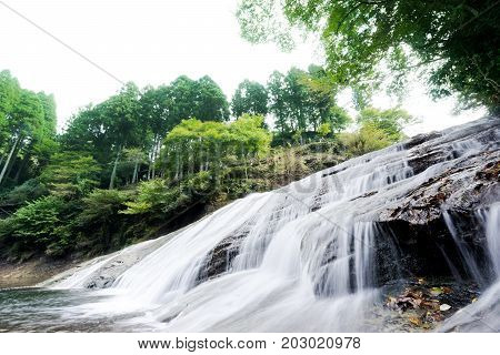 Japan travel concept - beautiful yoro keikoku valley waterfall under sun glow and morning blue sky in Chiba Prefecture Japan