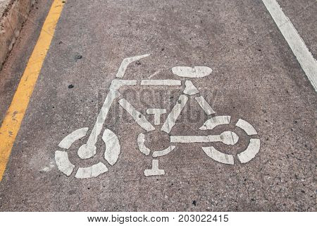cycle path with white arrow and mosaic of a bicycle on red stone surface