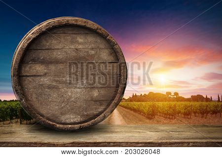 Red wine with barrel on vineyard in green Tuscany, Italy.