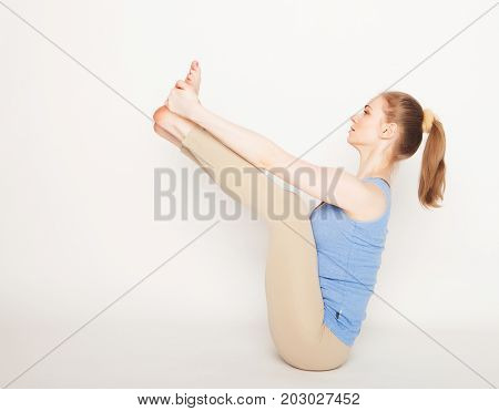 lifestyle, sport  and people concept: young woman in yoga pose sitting on a floo