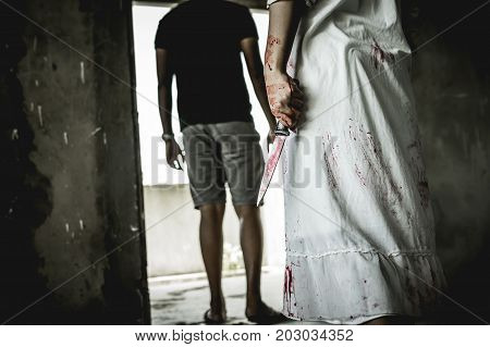 Asian girl dress killer to Halloween festival She's holding a kitchen knife big soaked in blood with scary eyes ready to kill a man in front of her.