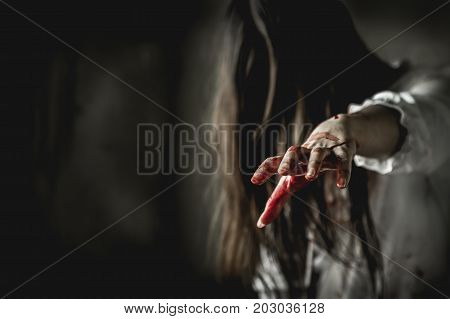 Asian girl dress killer to Halloween festival She's holding a kitchen knife and a big soaked with blood with terrible eyes ready to kill people.