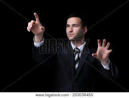 Business man pushing the imaginary  button. Isoladed on black.