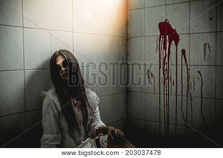 Asian girl dress killer to Halloween festival She's holding a kitchen knife and a big soaked with blood with terrible eyes ready to kill people.
