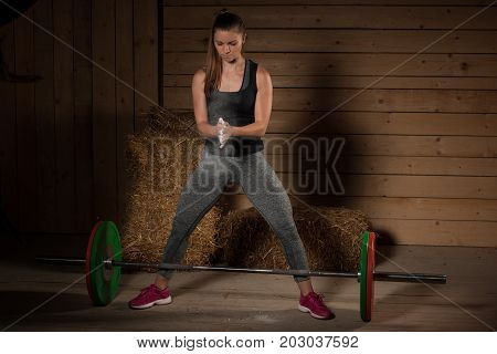 Active Young Fit Woman Claping Hands With Magnesium On Them Before Lifting Barbell Weights