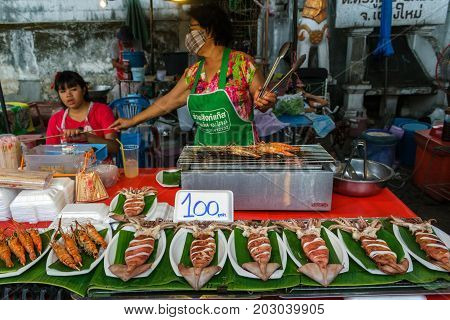 CHIANG MAI THAILAND - 6/13/2015: A woman cooks seafood at the Sunday walking street market.