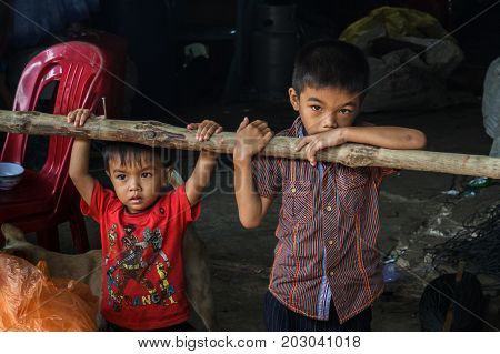 Two boys stand just outside their home in a fishing village in Sihanoukville Cambodia.