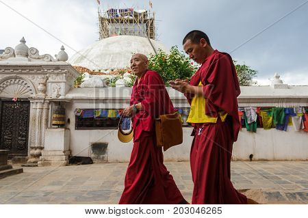 KATHMANDU NEPAL - 9/23/2015: Tibetan monks walk around the Boudhanath Stupa in Kathmandu Nepal.