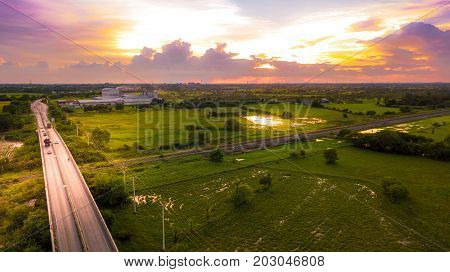 Aerial Photo Countryside Car Running on Road Bridge Over Railway Bypass route the City and Golden Hour Sky Beautiful Landscape Drone View