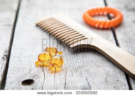 Hair Nurishment. Vitamin Serum Capsule On Wooden Background