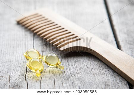 Hair Nurishment. Vitamin Serum Capsule On Wooden Background