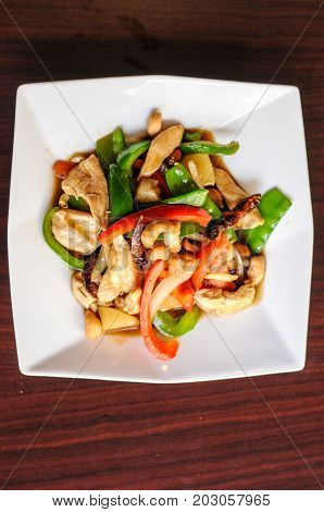 Stir-Fried Cashew Chicken, Slices of chicken breast stir-fried with cashew nuts, peapods, pineapple, onions, tomato ,and bell peppers