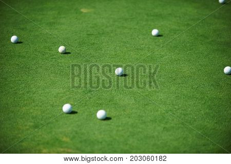 white golf balls on green field close up