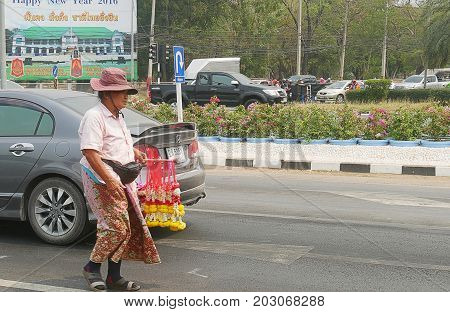 THAILAND--A woman sells flower leis to vehicles at a traffic light in one of the roads to the northern part of Thailand. Photo taken in March 2016.