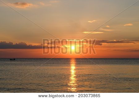 Sunset at sea with boat at Chaolao Tosang Beach Thailand.