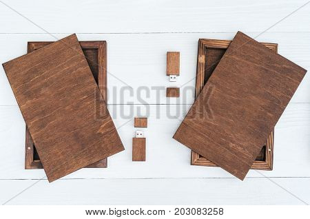 Empty blank wooden boxes for gift or photos with usb stick free space. Packaging for photo and USB drives on white wooden background. Information and mail concept
