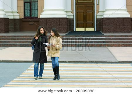 Dos jóvenes estudiantes en el cruce de peatones.