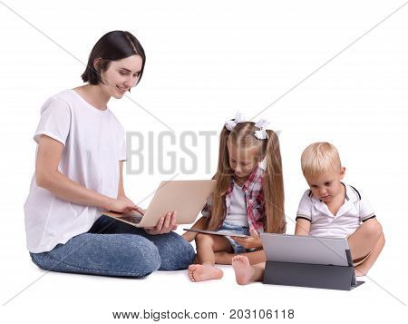 Cute little girl and a boy playing on tablets with their nanny isolated on a white background. Modern technologies, tablets, entertainment, new concept. amily concept.
