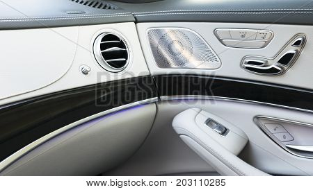 AC Ventilation Deck Luxury Car Interior. Door handle with Power seat control buttons of a luxury passenger car. White leather interior of the luxury modern car.