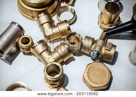 Scattering of various brass sanitary products. Abstract industrial background.