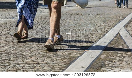 Paris- July 62017: Deatail image of the legs of an unidentified couple walking on the famous Boulevard Champs Elysees closed for car traffic. Each first Sunday of the month The Boulevard is closed for car traffic.