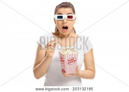 Scared girl with 3D glasses and popcorn looking at the camera isolated on white background