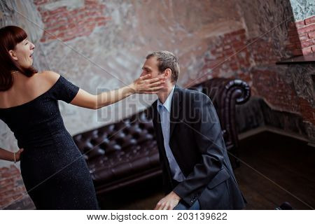 A woman is slapping a man. Wife swung at her husband. Family drama. Family scandal. Conflict in the family.