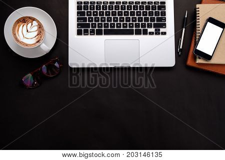 Top view of office leather desk table with a lot of things on it. Office desk concept with copy space.