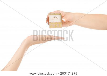 Female hand gives a box with a gold ring on a white background isolation