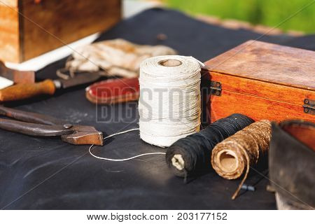 Old fashioned shoemaker set - shoes spools of thread tools workpieces. Historical reconstruction of 19 centure.