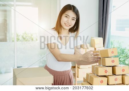 Young asian girl is freelancer with her private business at home office working with laptop coffee online marketing Customer order and packaging or packing.