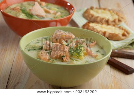Finnish fish soup kalakeitto with salmon and cream on a rustic table
