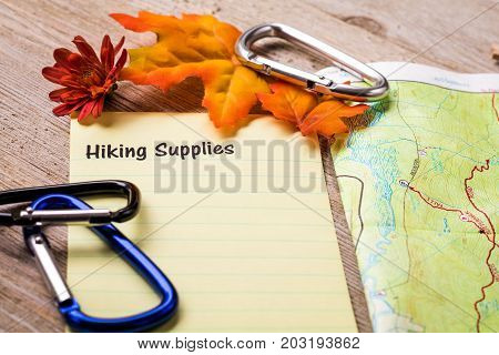 Fall Hiking Supplies list concept on notebook and wooden board