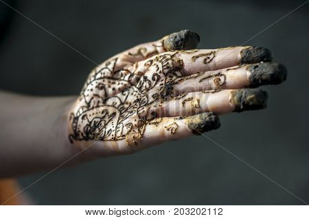 A girl showing her hand decorated with hanna desighn called 'Mehendi'