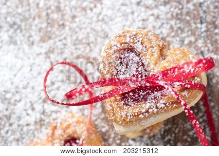 Valentine cookies with ribbon and icing sugar close up.