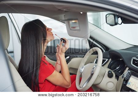 woman in car indoor keeps wheel turning around smiling looking at passengers in back seat idea taxi driver against sunset rays Light shine sky Concept of exam Vehicle - second home the girl.