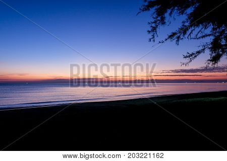 Sunset at sea with trees sway at Chaolao Tosang Beach Chanthaburi Thailand for background or texture.