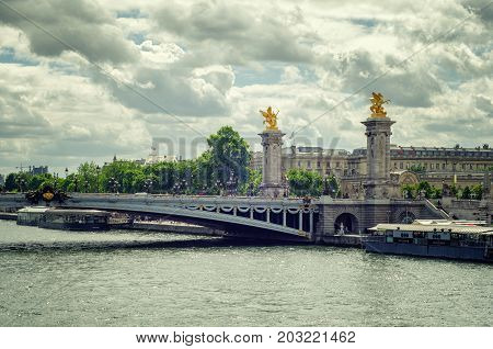 Paris,  France - June 4, 2017: Bridge Alexandre III with two gilded statues Fames in summer rainy day