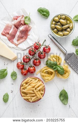 Italian Or Mediterranean Food Cuisine And Ingredients On White Concrete Table. Tagliatelle Pene Past
