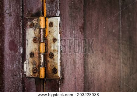 A rust hinge at the old wooden door. Protect Anti-theft Protection.