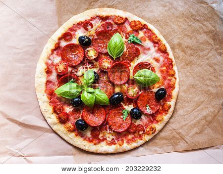 Pizza pepperoni with Ham Pepperoni and Bacon on baking craft paper background with fresh ingredients for you to design and restaurant menu. Delicious Homemade Meat pizza
