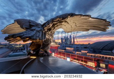 MOSCOW - SEP 19, 2015: Rooftop of Kievsky railway station with eagle sculpture and view of Moscow city skyscrapers