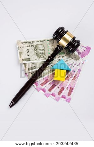 stock photo of india and real estate law, Indian law for real estate / construction company  / architects / builders or buyers showing small house model, gavel / hammer, indian currency notes