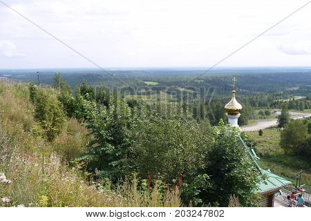 View from the mountain on the woody area with an orthodox chapel at the foot of a hill