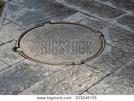 Close up on Manhole cover on garden pavement